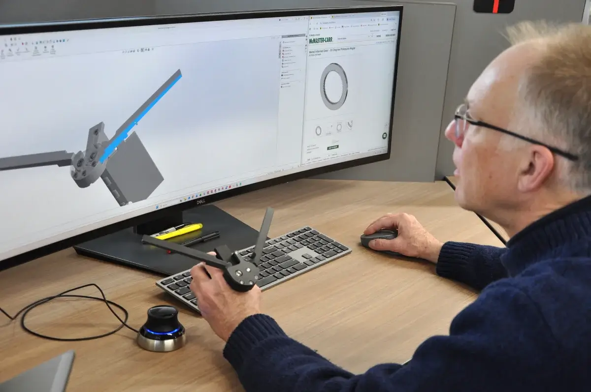 Mechanical engineer performing CAD rendering for precision mechanical assemblies and product design optimization at a workstation.